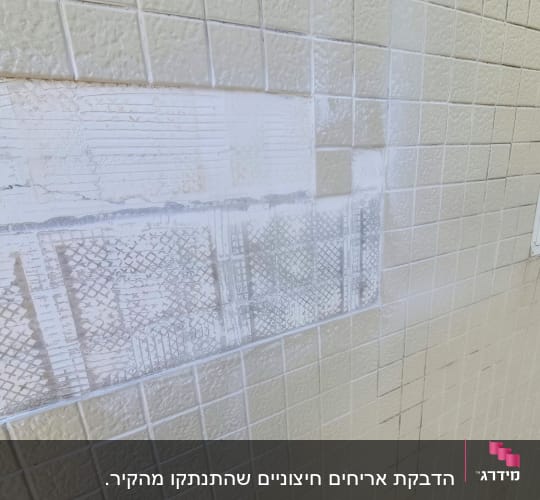 אריחים על קיר עם סימני הסרה
